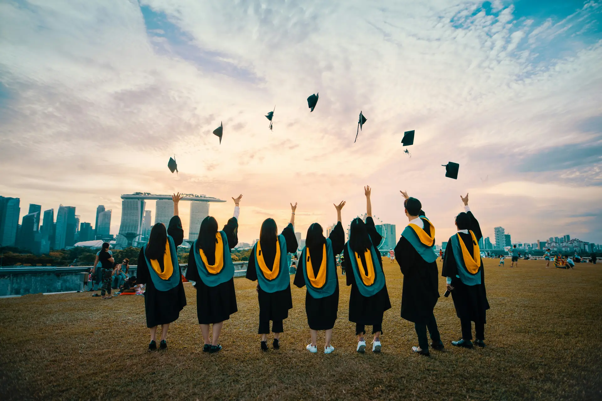 Graduates throwing their caps in the air against a city skyline